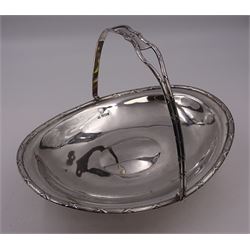 Late Edwardian silver swing handled basket, of oval form, with reed and ribbon border, upon oval foot, hallmarked James Deakin & Sons, Sheffield 1909, including handle H19.5cm