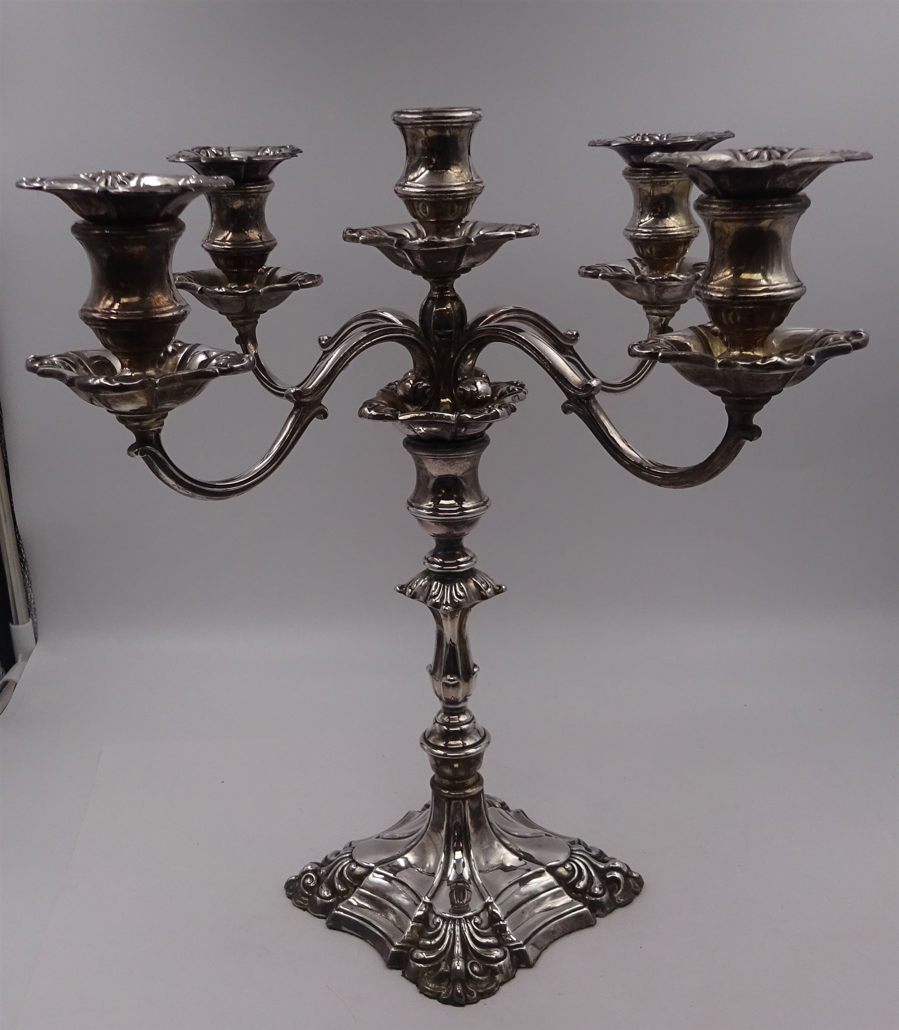 Modern silver five branch candelabra centrepiece, the four extending branches each with removable sconces, surrounding a central candle holder, upon a knopped stem and weighted stepped square foot, with anthemion to each corner, hallmarked Roberts & Belk, Sheffield 1984, H36cm 