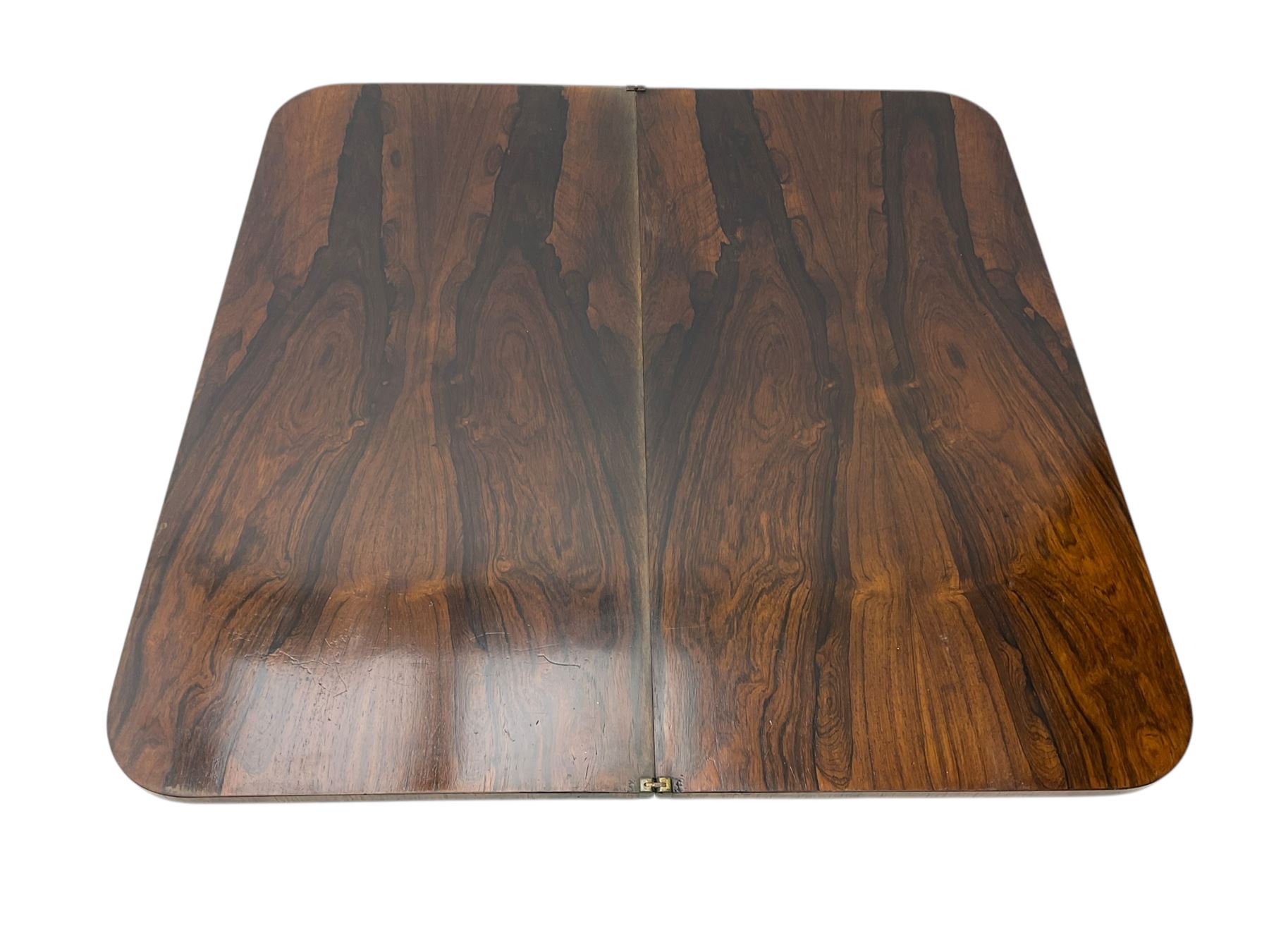 Victorian mahogany tea table, rectangular top with rounded corners, folding and swivelling to reveal interior surface, supported on a faceted baluster-shaped column, raised on a circular platform base with carved acanthus details, ending in four lion paw feet