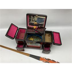 Oriental lacquered jewellery box, the body decorated with a black and red mountainous riverscape enclosing a glass compartment with simulated ivory rickshaw figure and three hinged lids opening to reveal mirror and various compartments and painted ceremonial stick