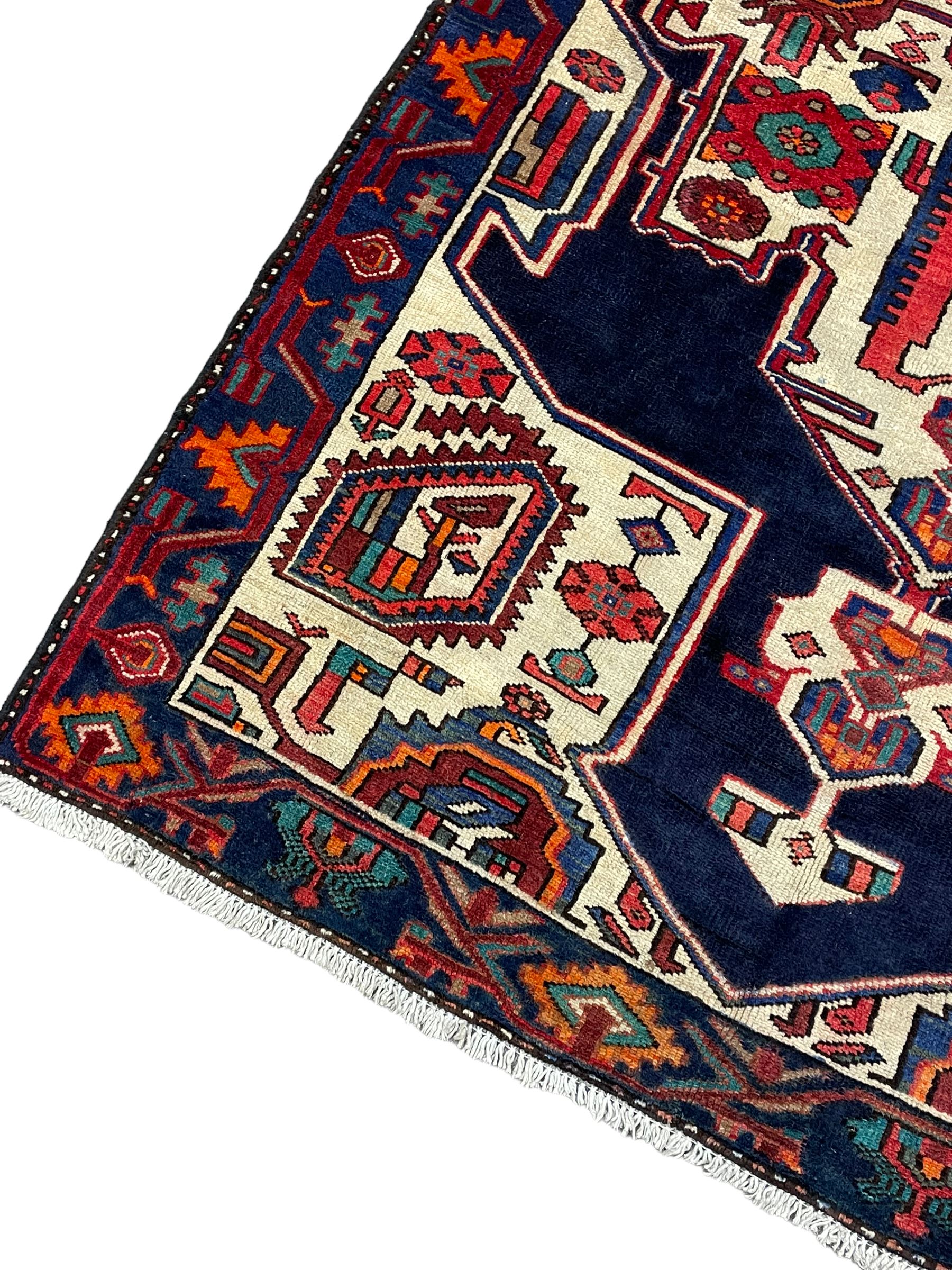 North West Persian Heriz rug, blue and ivory ground, decorated with stylised plant motifs, the border decorated with repeating geometric design 