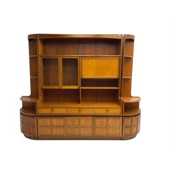 Nathan - mid-20th century teak wall display unit, fitted with glazed doors, fall-front drinks cabinet and three short drawers, with pair matching corner side units, shelf over double cupboard