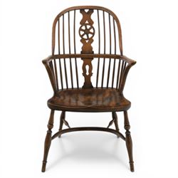 Late 19th century stained elm and beech Windsor armchair, the arched hoop back with pierced wheel splat above shaped lower splat between turned spindles, shaped arm rail on turned supports, saddle seat, raised on turned legs united by a crinoline stretcher