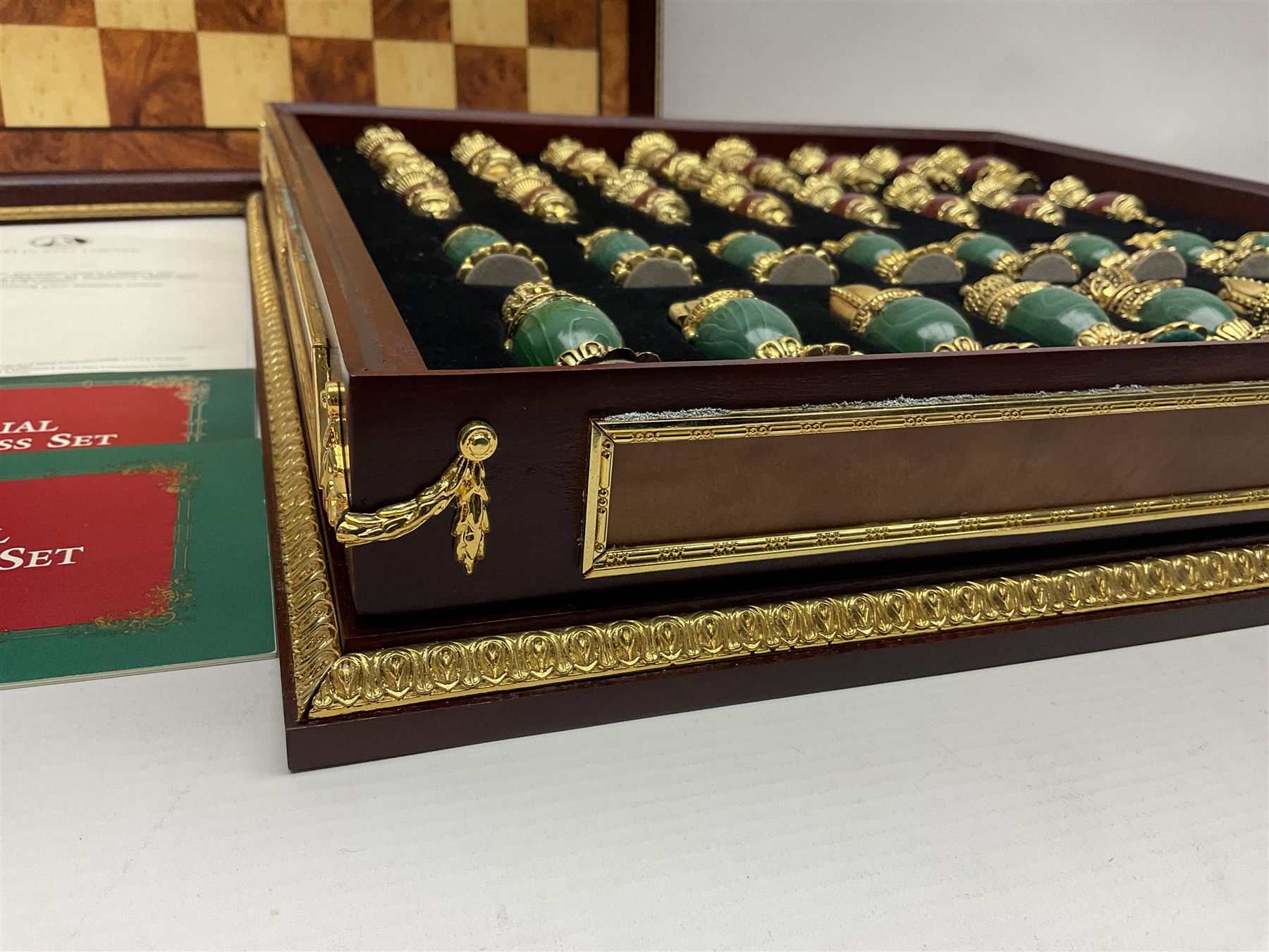 Franklin Mint House of Faberge 'The Imperial Jewelled Chess Set', to include set of chess pieces with malachite finish and a set with carnelian finish and a hardwood chess board