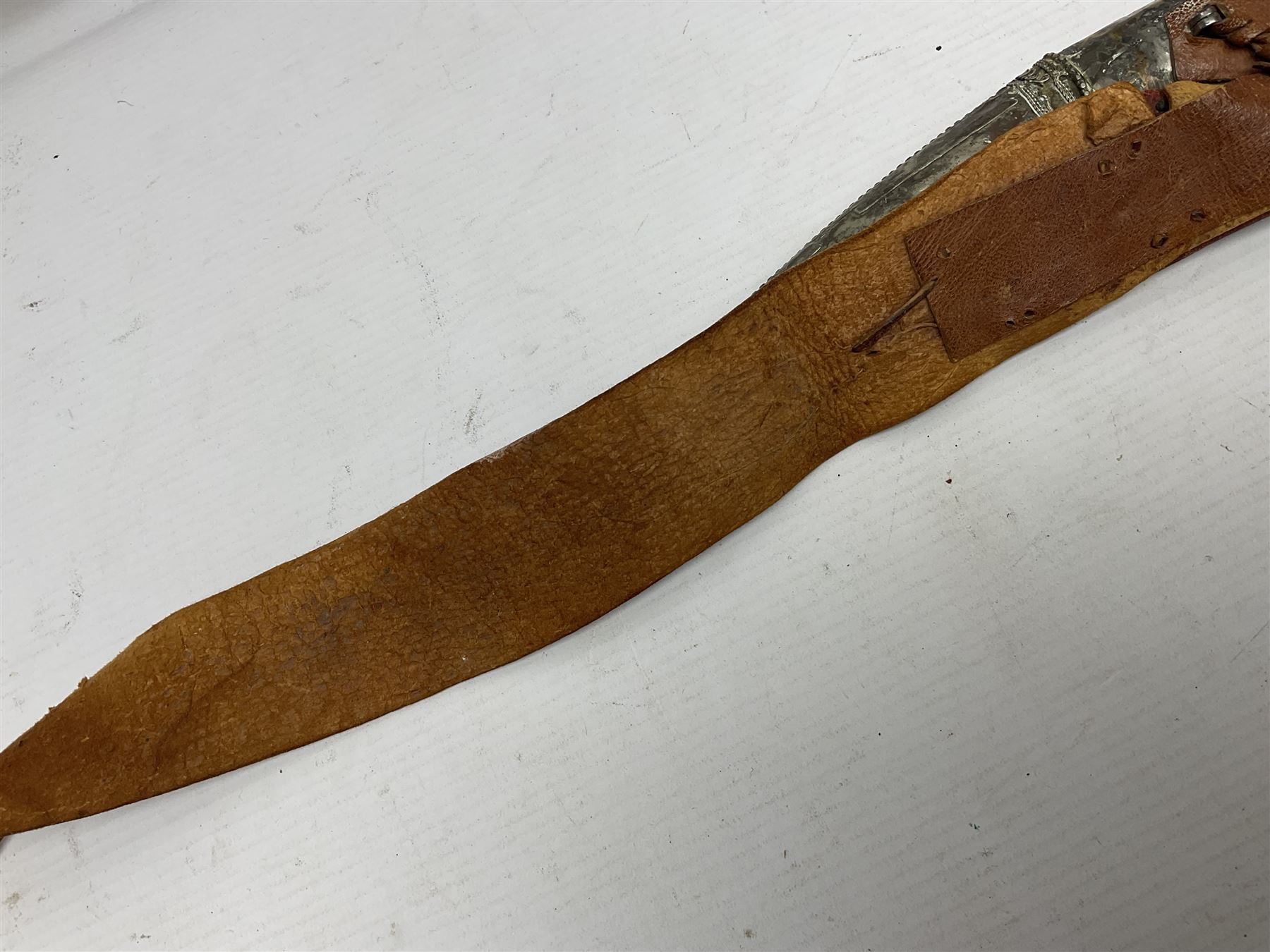 Saudi Arabian khanjar dagger with 29.5cm curving double edged  steel blade; white metal and copper mounted horn grip; in white metal mounted brass and leather scabbard incorporating embroidered leather wearing strap