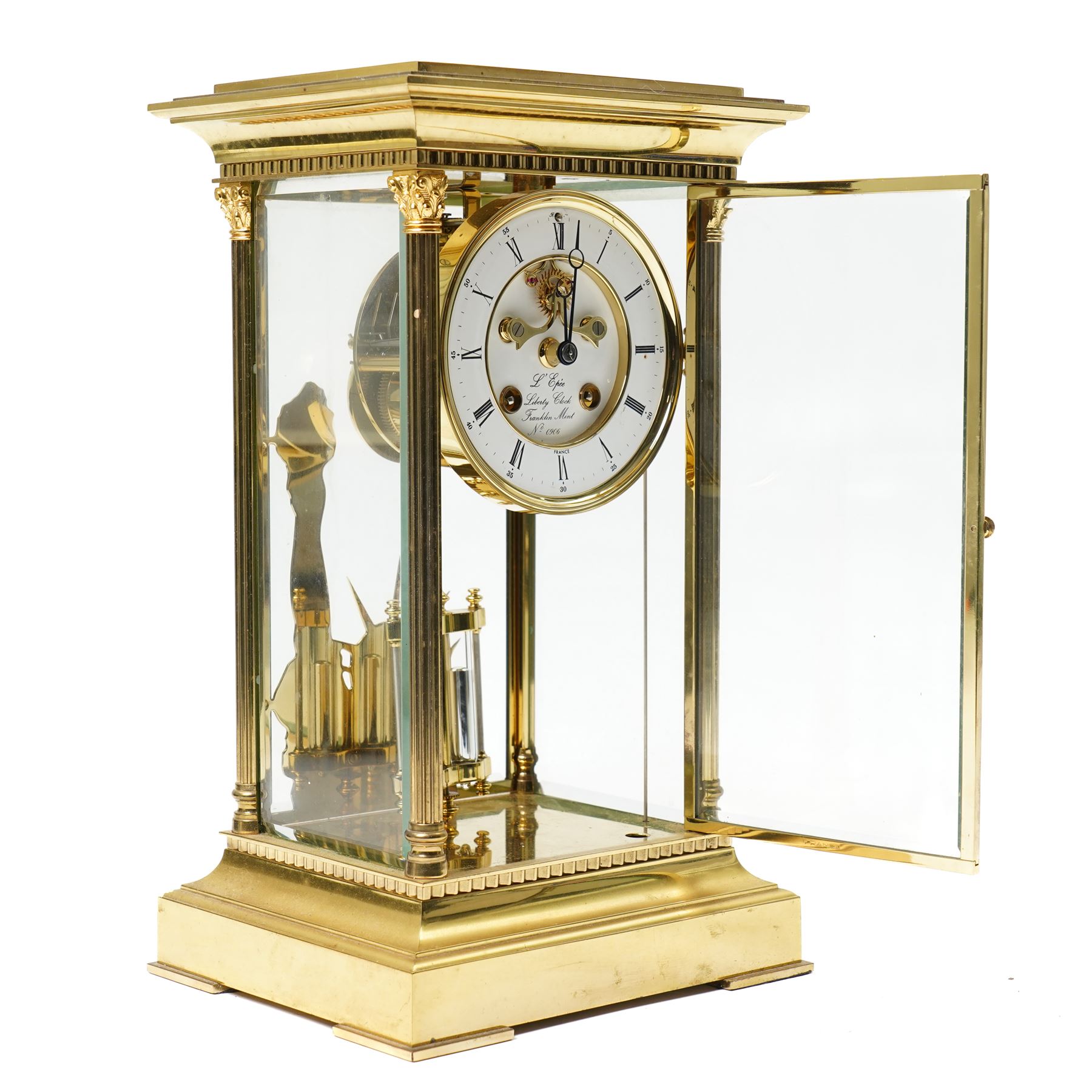 American-20th century Franklin Mint  8-day four-glass mantle clock, brass case with bevelled glass to the doors and sides, with reeded columns and Corinthian capitals to the corners, enamel dial with Roman numerals and five minute Arabic's, with steel moon hands and visible jewelled Brocot escapement, Dial inscribed L' Epee, Liberty Clock, Franklin Mint. No 0906 , with a twin file mercury pendulum and brass silhouette depiction of the Statue of Liberty to the rear of the case, twin train going barrel movement with rack striking.