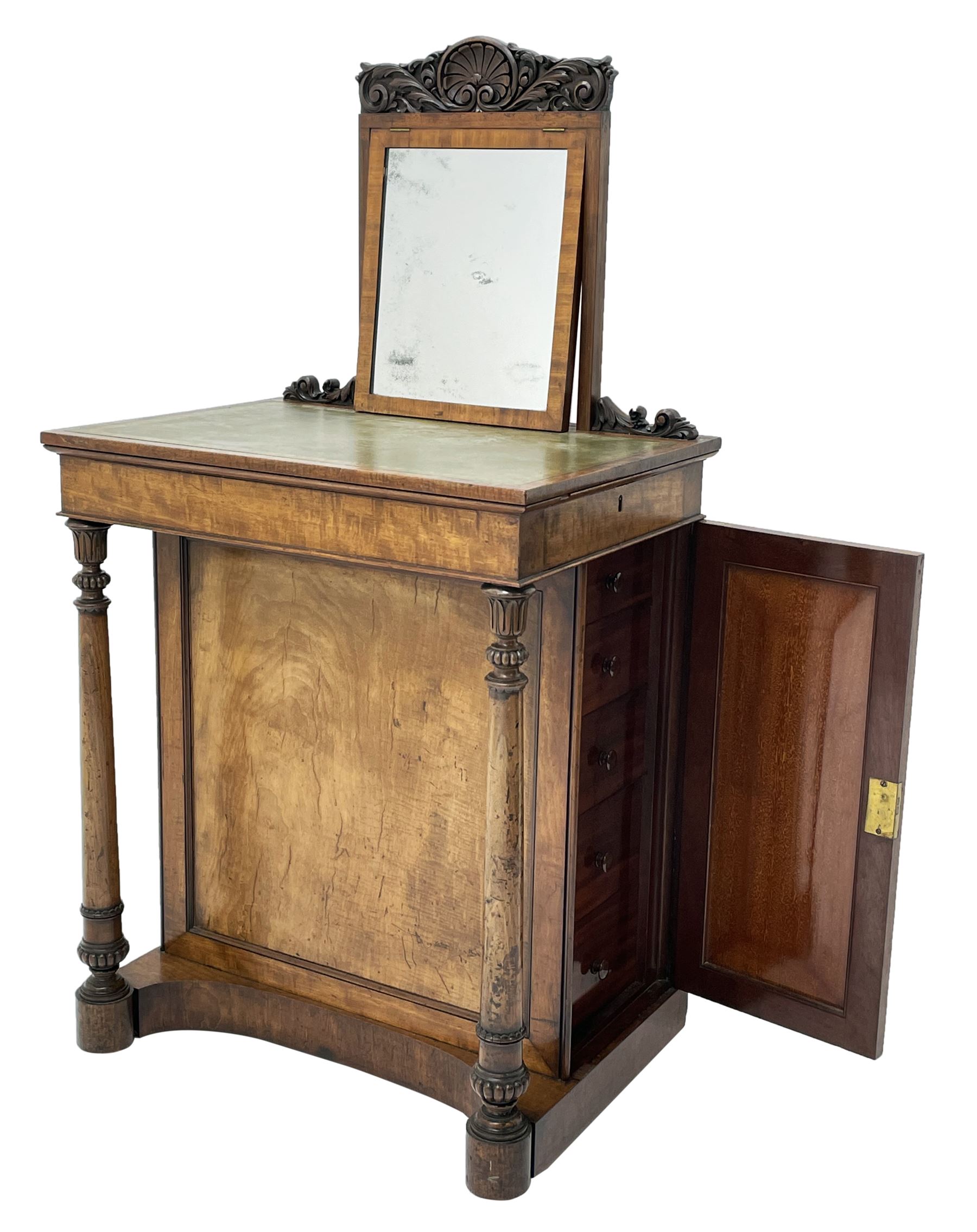 Early Victorian figured mahogany dressing cabinet, the raised shell and scroll carved back lifts to reveal rectangular easel mirror with mahogany band, flat rectangular top with tooled leather inset, slide at each side with matching leather inset, full width drawer above cupboard enclosing a series of five drawers, turned front supports, panelled front, sides and back