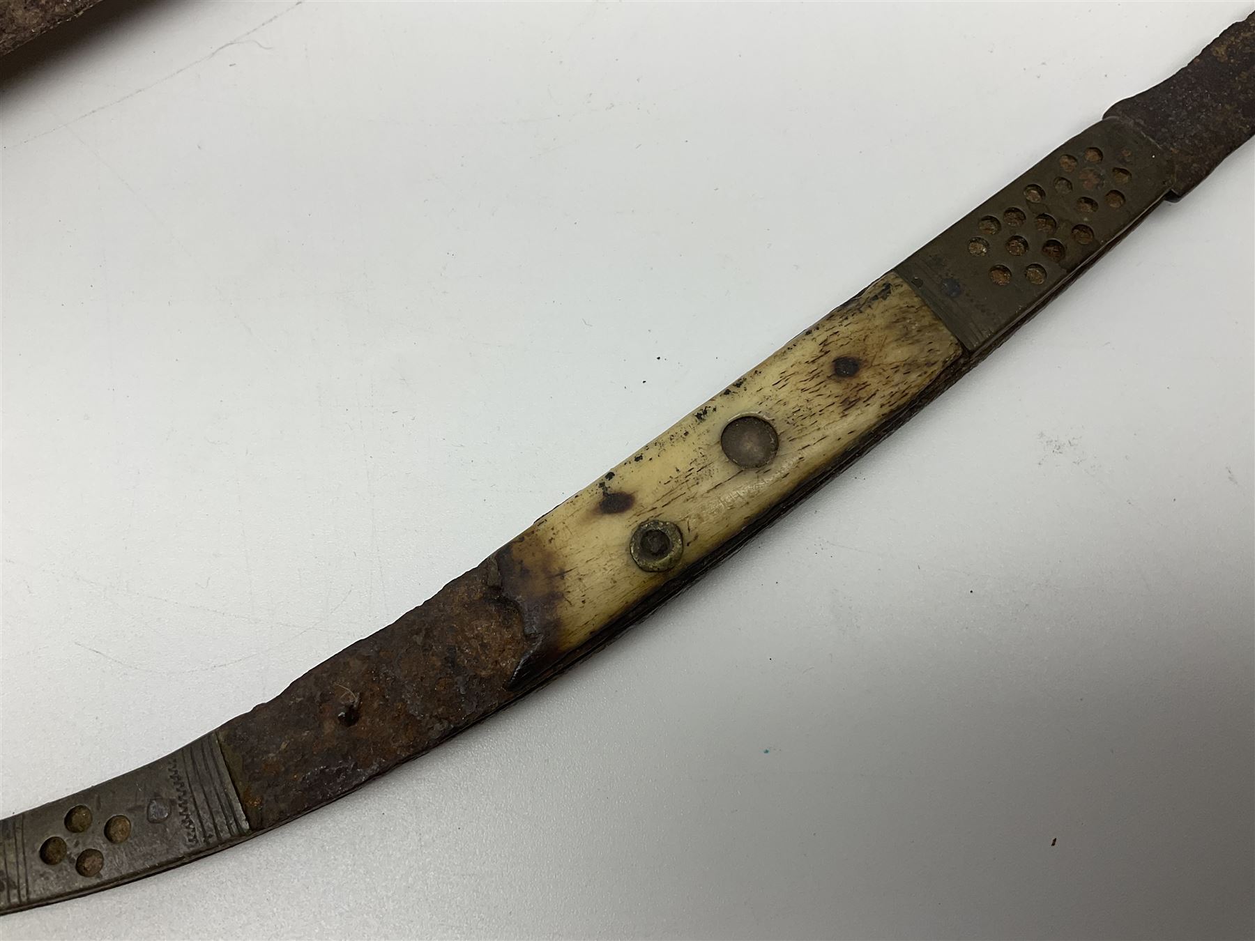 19th century continental folding knife with 15.5cm single edged blade, the pierced brass and iron handle with remains of horn grips L21.5cm overall closed; turned horn handled knife with foliate engraved blade; battlefield relic German 1884/98 knife bayonet; iron spear head; leather covered swagger stick; and two-piece gun cleaning rod