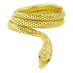 18ct gold coiled diamond snake bangle, the head set with round cut diamonds and emerald ey...
