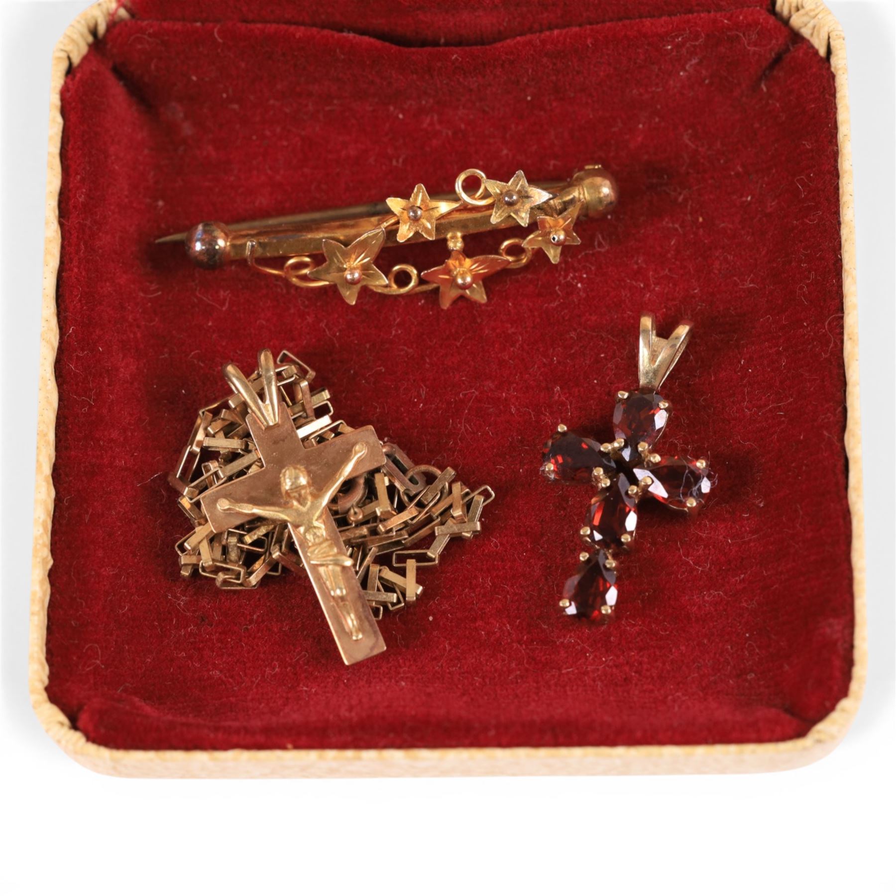 9ct jewellery, comprising stone set cross pendant, crucifix pendant on gold chain and a vine brooch, all stamped or hallmarked