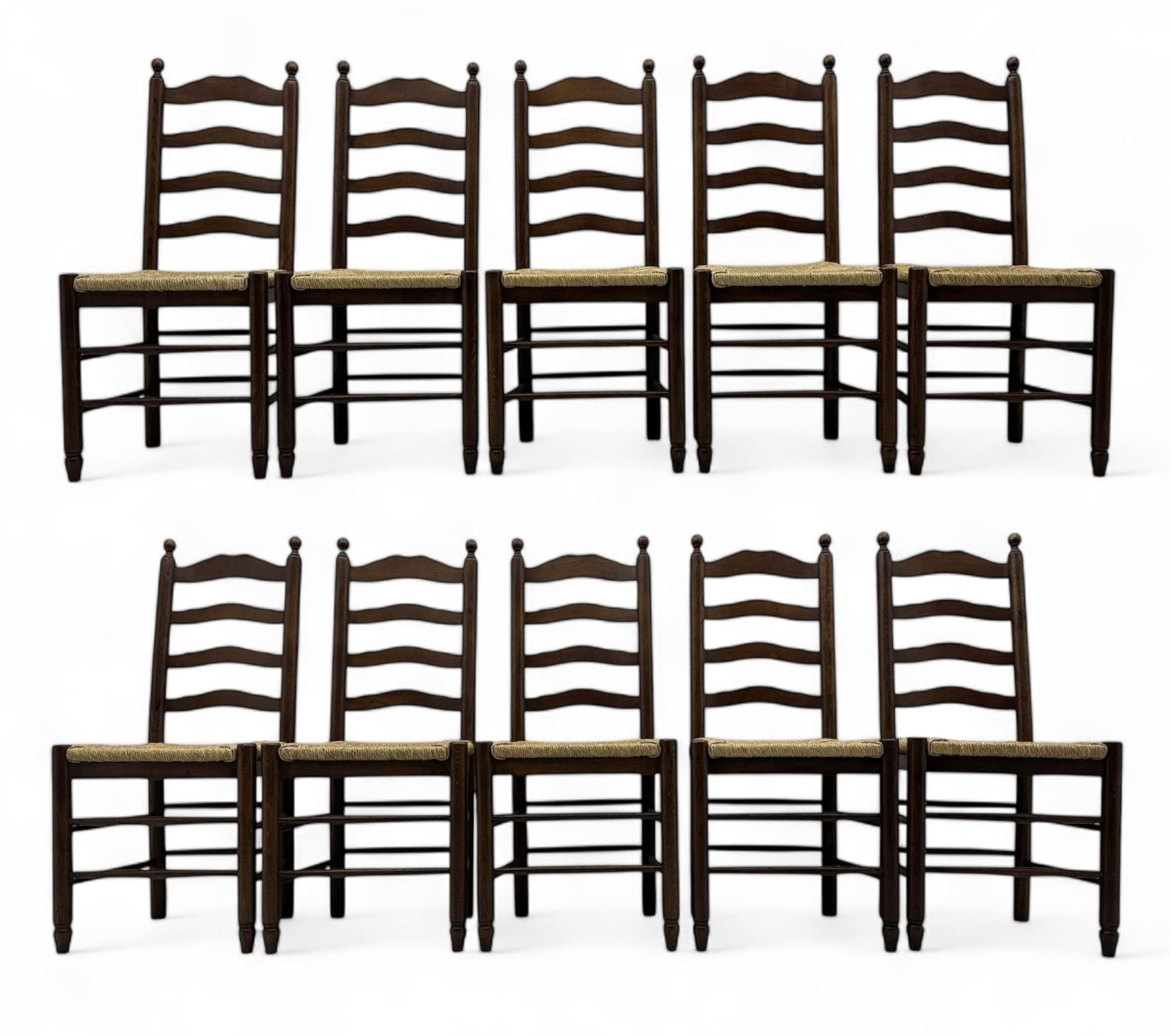 Set of ten 18th century design oak ladder back dining chairs, shaped cresting rail over four horizontal splats, rush seat raised on turned supports united by double stretchers