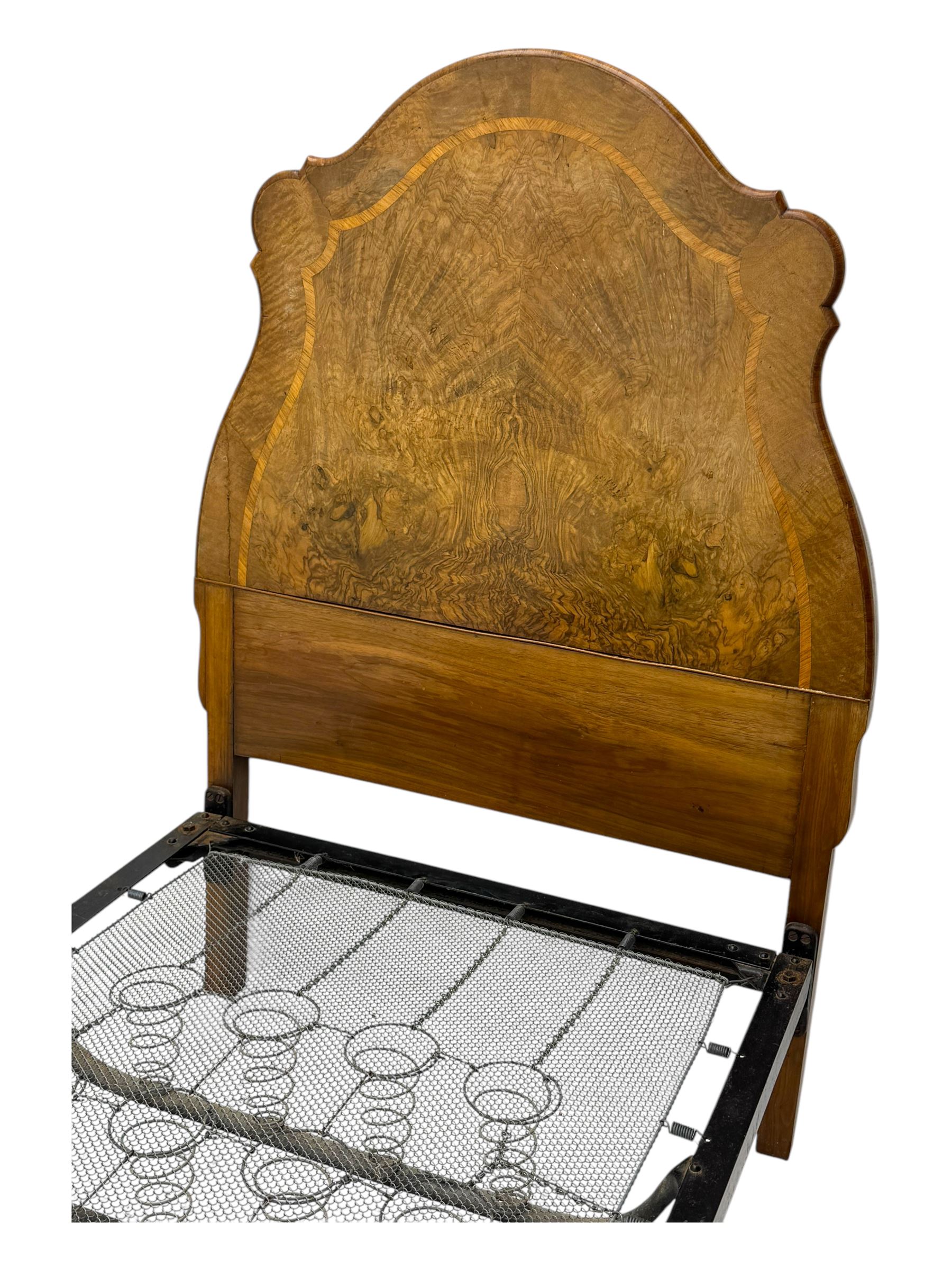 Mid-20th century walnut single bedstead, high shaped headboard, footboard with turned finials and scrollwork carvings, complete with 'Vono' iron frame, raised on cabriole supports