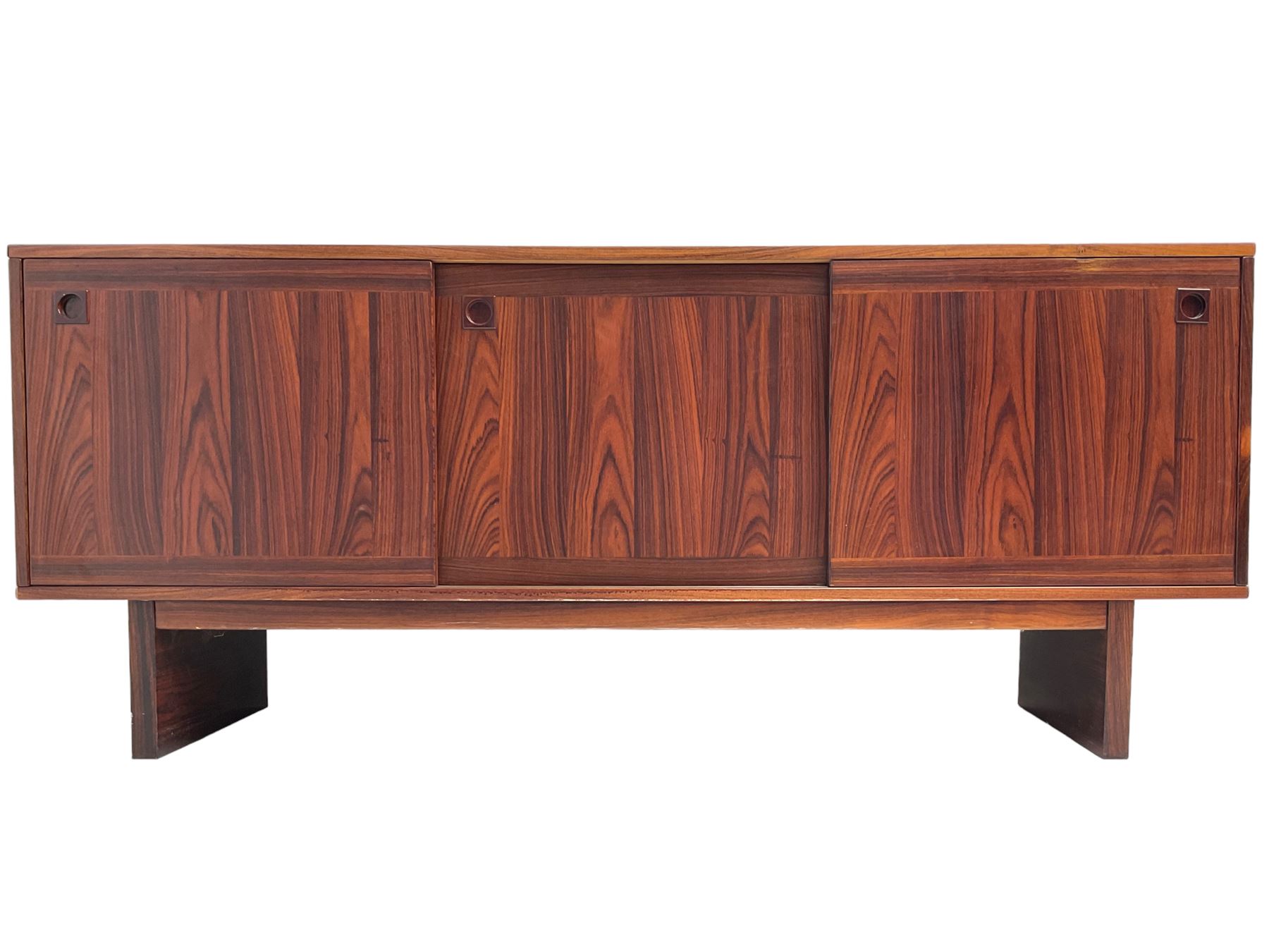 NH Chapman & Co Siesta - mid-20th century sideboard, fitted with three sliding doors, enclosing two drawers and shelves, raised on twin end supports