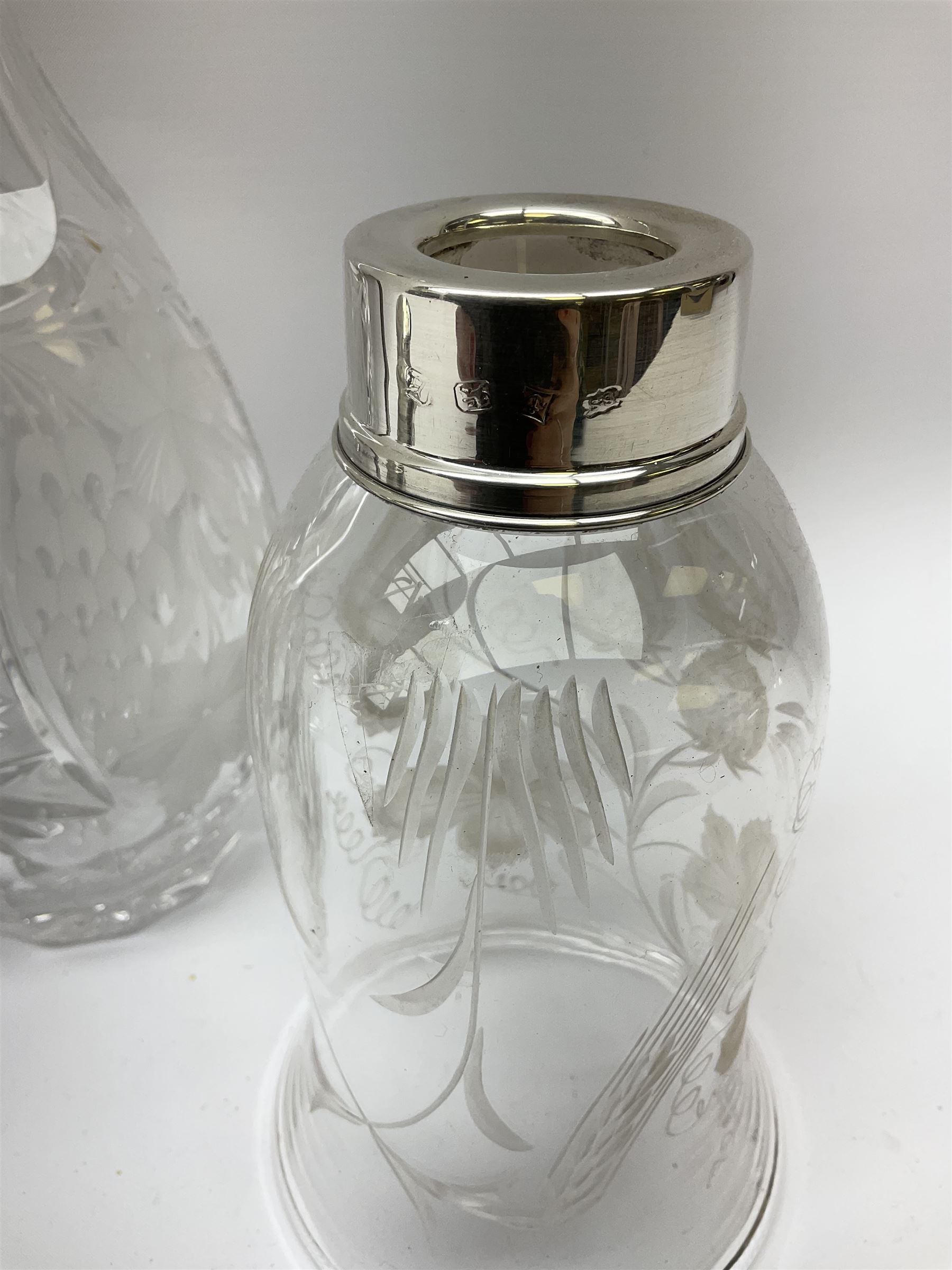 Clear glass decanter of slender oviform with silver collar stamped MN & WB 925, Mappin & Webb, together with an early 20th century silver photo frame hallmarked G & C Ltd of Birmingham, two clear glass shakers with pierced silver tops and silver collared glass storm lampshade with etched decoration, tallest H37.5cm