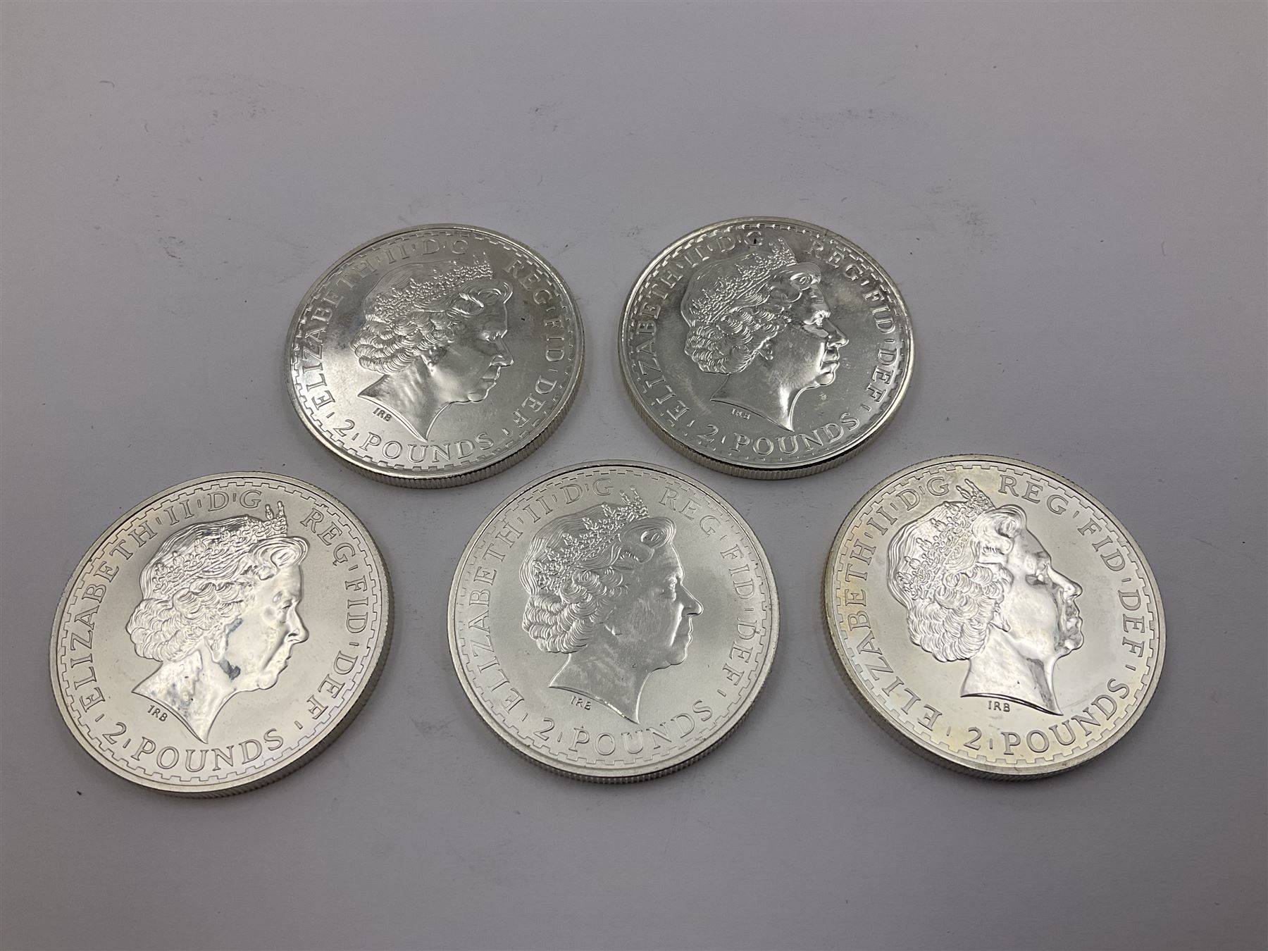 Five Queen Elizabeth II United Kingdom one ounce fine silver Britannia two pound coins dated 2002, 2003, 2004, 2005 and 2006