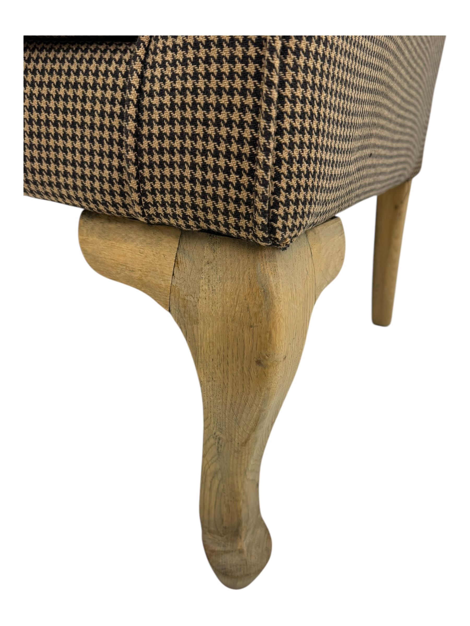 Hardwood-framed wingback armchair, upholstered in dog tooth pattern fabric, on cabriole supports 