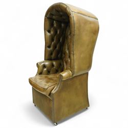 20th century George II style leather upholstered hall porters chair, brass studded upholstered with piping in leather on all sides, the inside top back arms and seat are all pleated and deep buttoned, with removable seat pad, on castors
