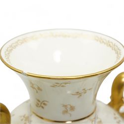 Early 20th century Royal Worcester porcelain twin handled vase, circa 1910, painted with a basket of flowers by Ernest Phillips, within an oval gilt border, the plain ground decorated with gilt sprigs and trailing oak leaves, signed, printed marks beneath, H21.5cm