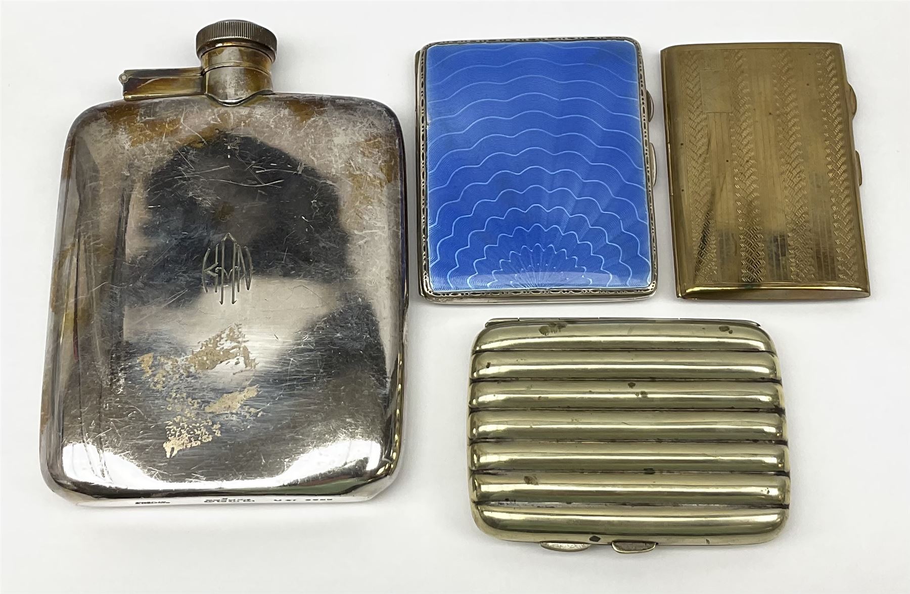 A silver plated hip flash, H14cm, together with a guilloche enamel and silver plated cigarette case, a silk plated cigar case, and further base metal example. (4). 