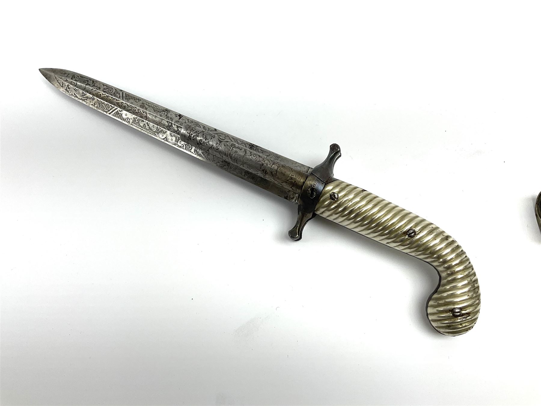Rare double barrel percussion knife pistol by Dumonthier & Sons (NVN), approx. .38 calibre, with 8.5cm barrels and central 21.5cm spear pointed blade, all with etched damascening, upper quillons serve as hammers for the percussion ignition with single drop down trigger and fluted nickel grips, in nickel mounted leather covered tin scabbard L33.5cm overall