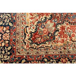 West-Central Persian Mahal hand-knotted carpet, terracotta field with a large central indigo and ivory medallion with floral palmettes and scrolling vines, framed by ivory spandrels with dense foliage within a broad navy border of lotus and palmette motifs linked by scrolling tendrils and multiple guard stripes 