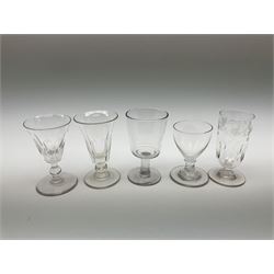 A collection of late Georgian/early Victorian glasses, to include custard cup, wine glass with engraved foliate detail, example with bucket shaped bowl, and other examples with faceted/sliced decoration to the bowls. (15). 