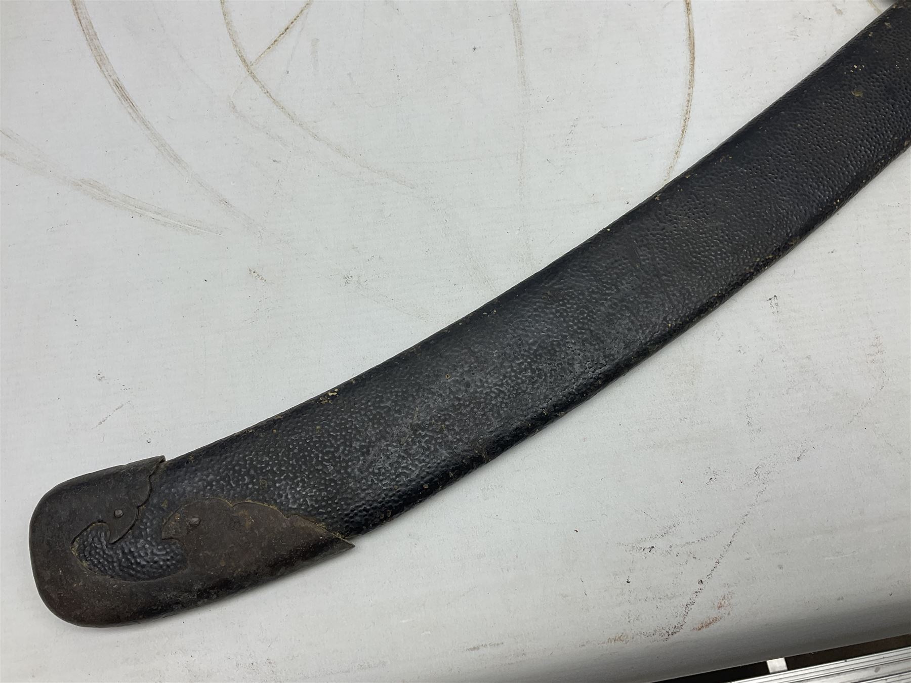 Chinese Boxer Rebellion Period Sword, 69.5cm heavy curved single edge blade with single narrow fuller, plain iron dished circular guard, iron pommel and ferrule with plaited cord bound grip; in skin covered wooden scabbard with iron chape and long suspension mount L95cm overall