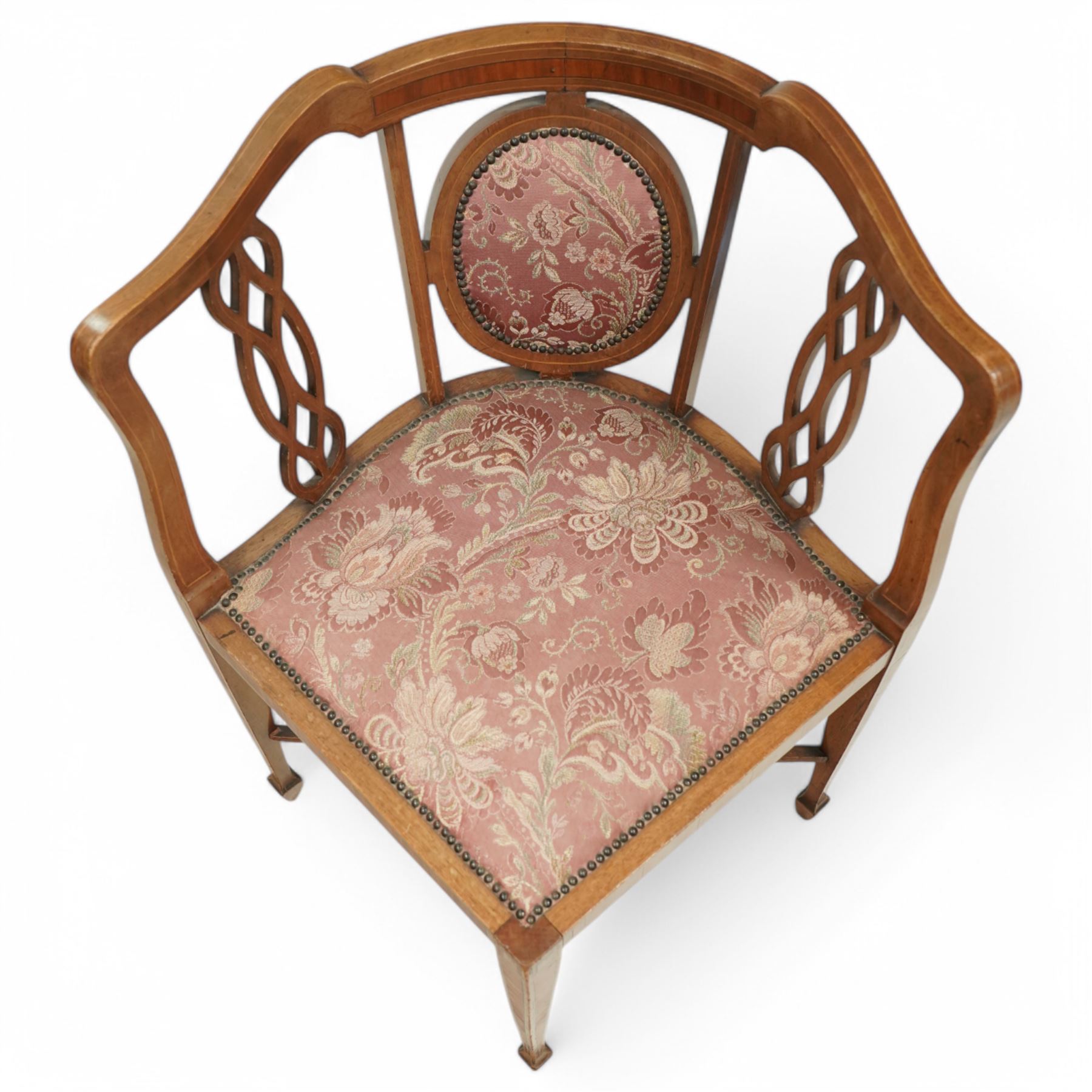 Edwardian inlaid mahogany corner chair, shaped cresting with satinwood band over interlaced splats, upholstered in floral pattern fabric, on square tapering supports with spade feet united by X-stretcher 