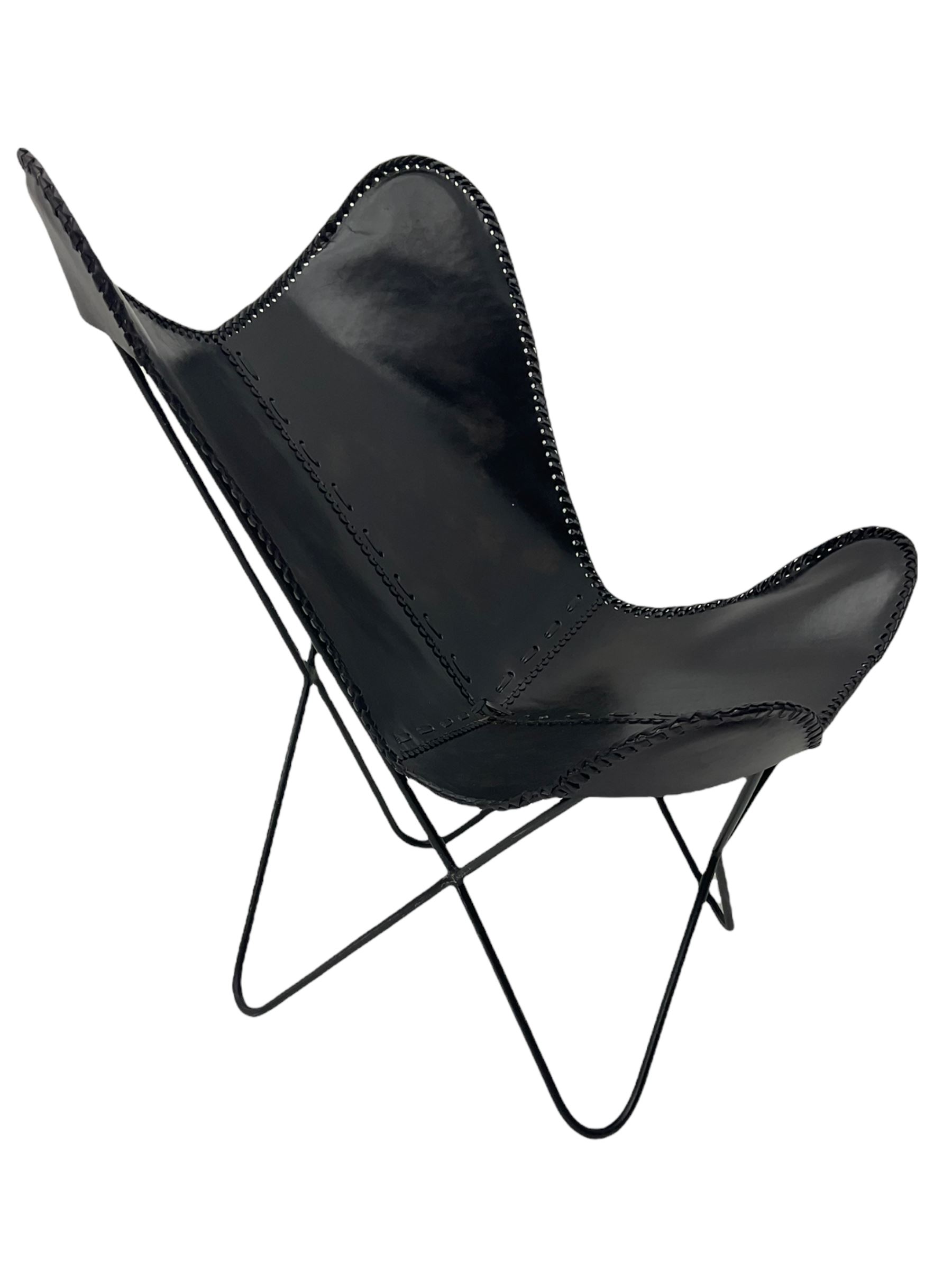 Metal framed butterfly chair upholstered in slung dark tan stitched leather 