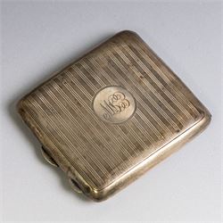 Two early 20th century silver cigarette cases, comprising a rectangular example with foliate decoration and vacant shield cartouche and a 1920s example with engine turned decoration and engraved initials, both hallmarked