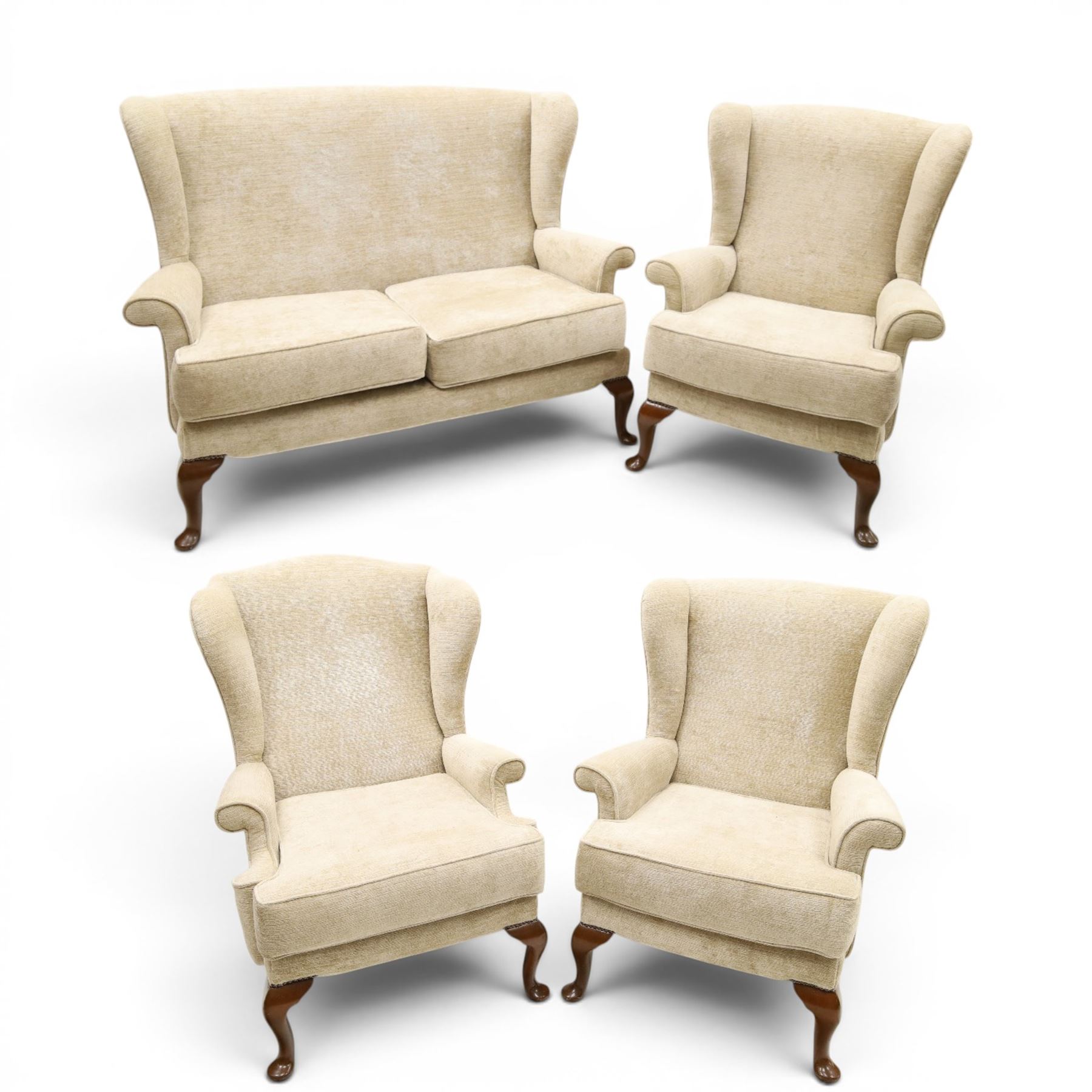 Parker Knoll - 'Hartley' lounge suite, comprising three wingback armchairs and two-seat settee, upholstered in cream fabric, shaped wing backs with scroll-over arms and loose seat cushions, on cabriole supports with pad feet wingbacks and settee

Armchairs: H 96cm, D 83cm, W 75cm