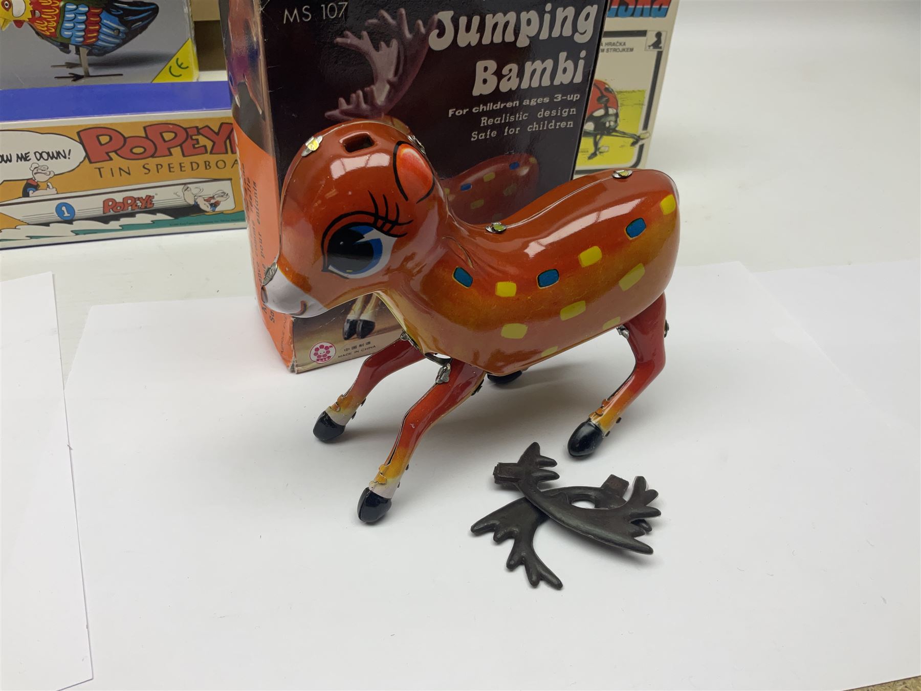 Twenty six tinplate models to include Ferris Wheel and Performing Circus Elephant, marked JW, further similar examples such as Duck on a Bike, Clown on Roller, Carousel; Popeye Tin Speedboat; Looney Tunes Wind Up Cars and Express Train; various international examples, MS107 Jumping Bambi, Pop Pop Boat, jumping frogs, pecking chickens etc; both boxed and loose