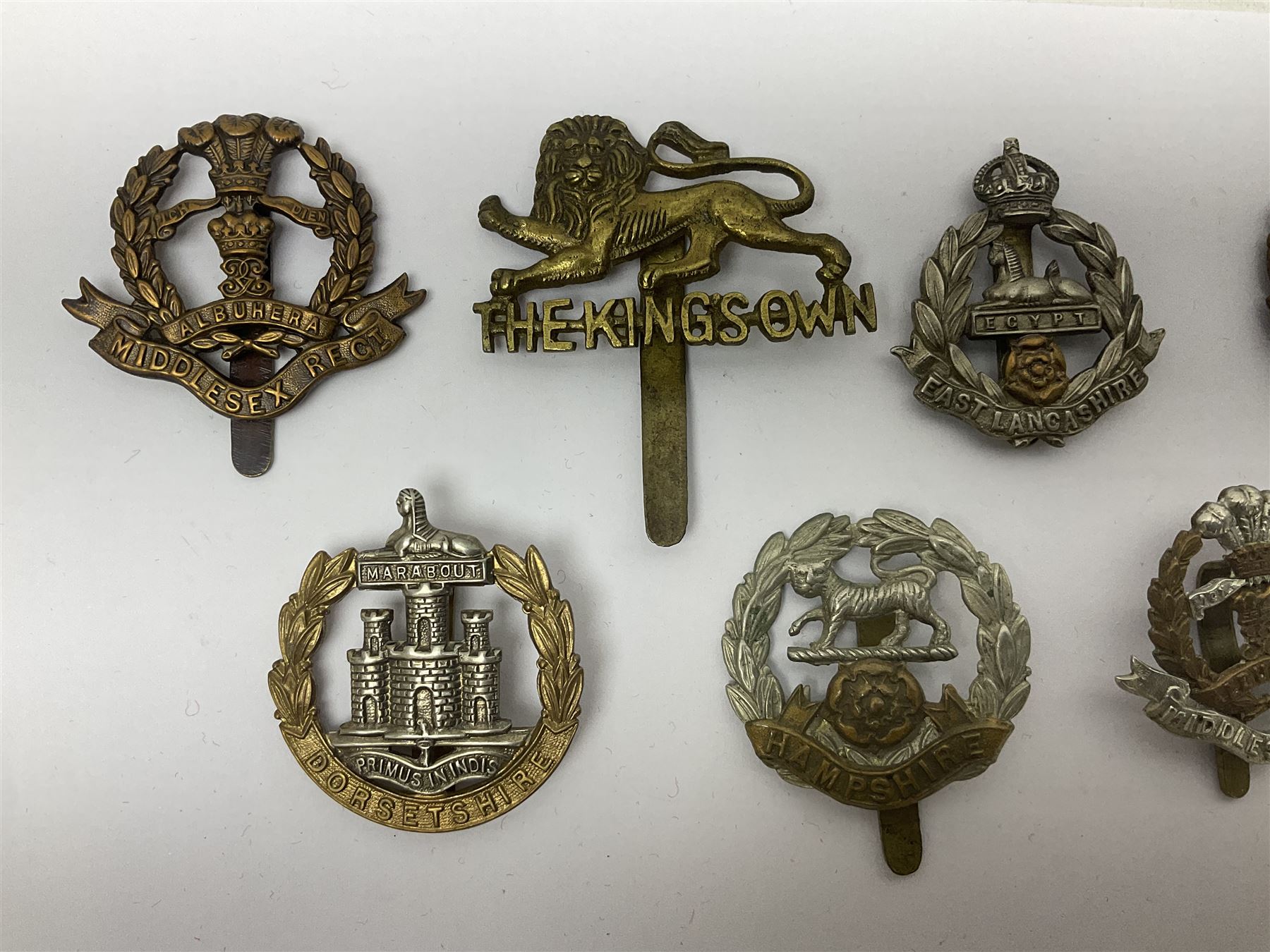 Seventeen regimental cap badges including Dorsetshire, Worcestershire, Staffordshire, Lancashire, Manchester, Middlesex, Berkshire, Bedfordshire etc (17)