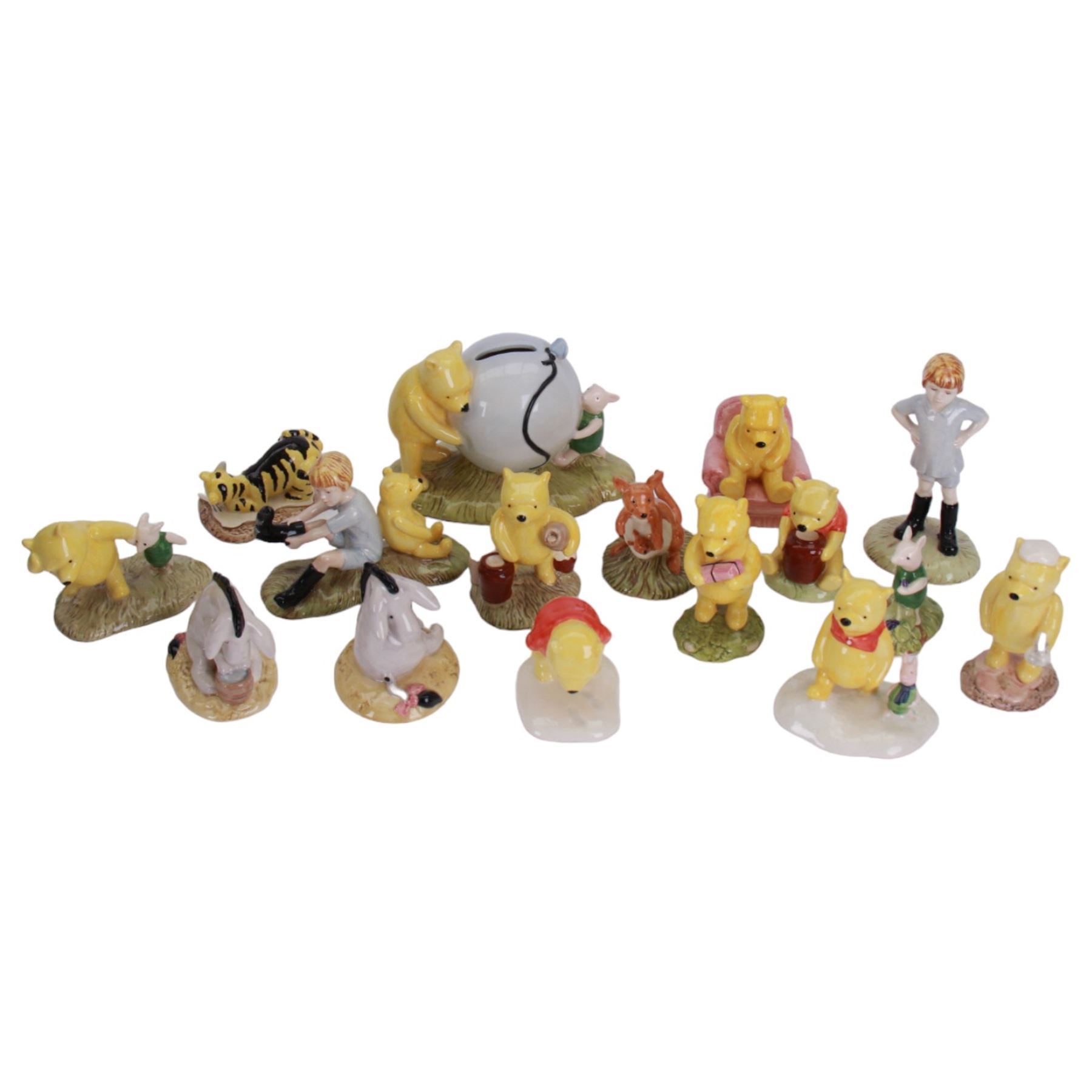 Sixteen Royal Doulton Winnie the Pooh figures, including Pooh's Blue Balloon money box, Winnie the Pooh in the Armchair, Piglet Picking Violets and Eeyore's Birthday etc, fifteen with boxes