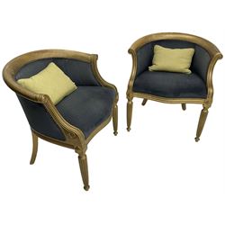 Pair of French design gilt framed tub shaped armchairs, scrolled arm terminal over moulded frieze rail, on reeded supports, upholstered in navy fabric with studwork