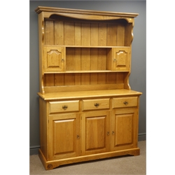  Royal Oak Furniture 'Yorkshire Rose' oak dresser, two shelves with plate rack, two cupboards, three drawers and three cupboards enclosing a shelf, on bracket support, with carved Rose signature on plinth, W133cm, H190cm, D47cm  