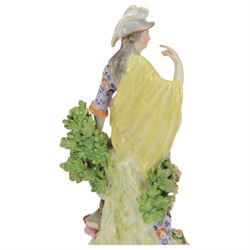 18th century Derby porcelain figure, circa 1775, modelled as Minerva, standing with mask shield, books and owl, against flowering bocage, upon a scroll base encrusted with flowers, H23cm