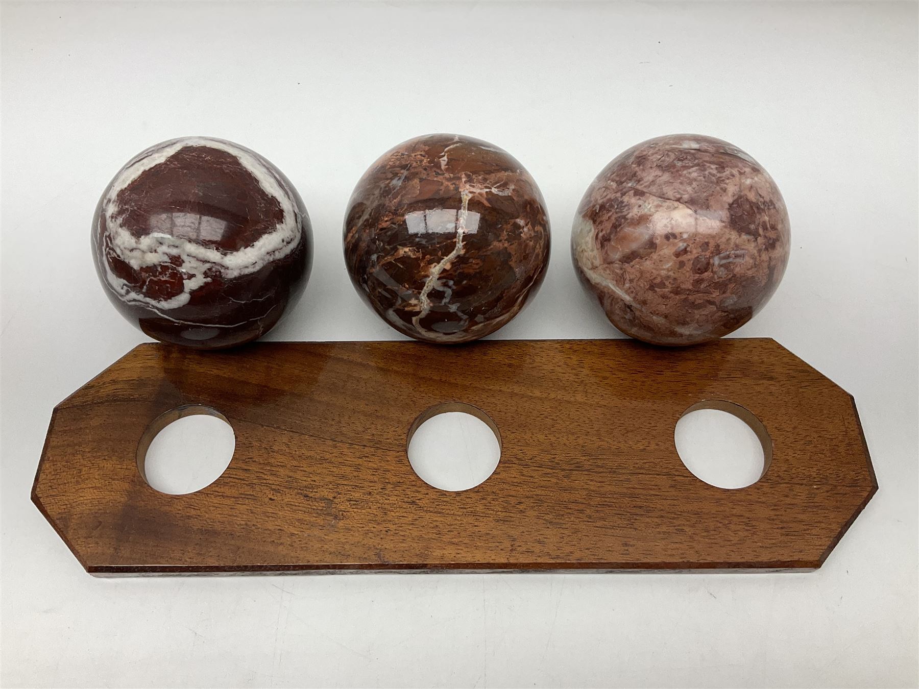 Set of three marble spheres on a elongated octagonal wooden base, H12cm