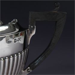 Victorian silver two piece bachelors tea service, comprising teapot and milk jug, of oval part fluted form, the teapot with ebonised wooden handle and finial, hallmarked Josiah Williams & Co, London 1895, together with a silver milk jug and open sucrier, of similar form, hallmarked William Hutton & Sons, London 1898