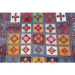 Persian Gabbeh indigo ground runner rug of garden design, the multi-coloured field decorated with five columns of panels in contrasting colours with stylised plant motifs, the guard band with trailing foliage