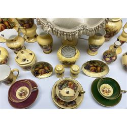 Collection of Aynsley Orchard Gold pattern wares, comprising lamp base, three jars and covers, six vases or various size and form, large jug, lidded dish, pair of cruets, pair of candlesticks, mug, two pin dishes, lobed dish, tea cup, saucer, size plate, and cake plate, and two further cups and saucers, each cup decorated with central Orchard Gold reserve to the interior against a mottled pink or green ground. 