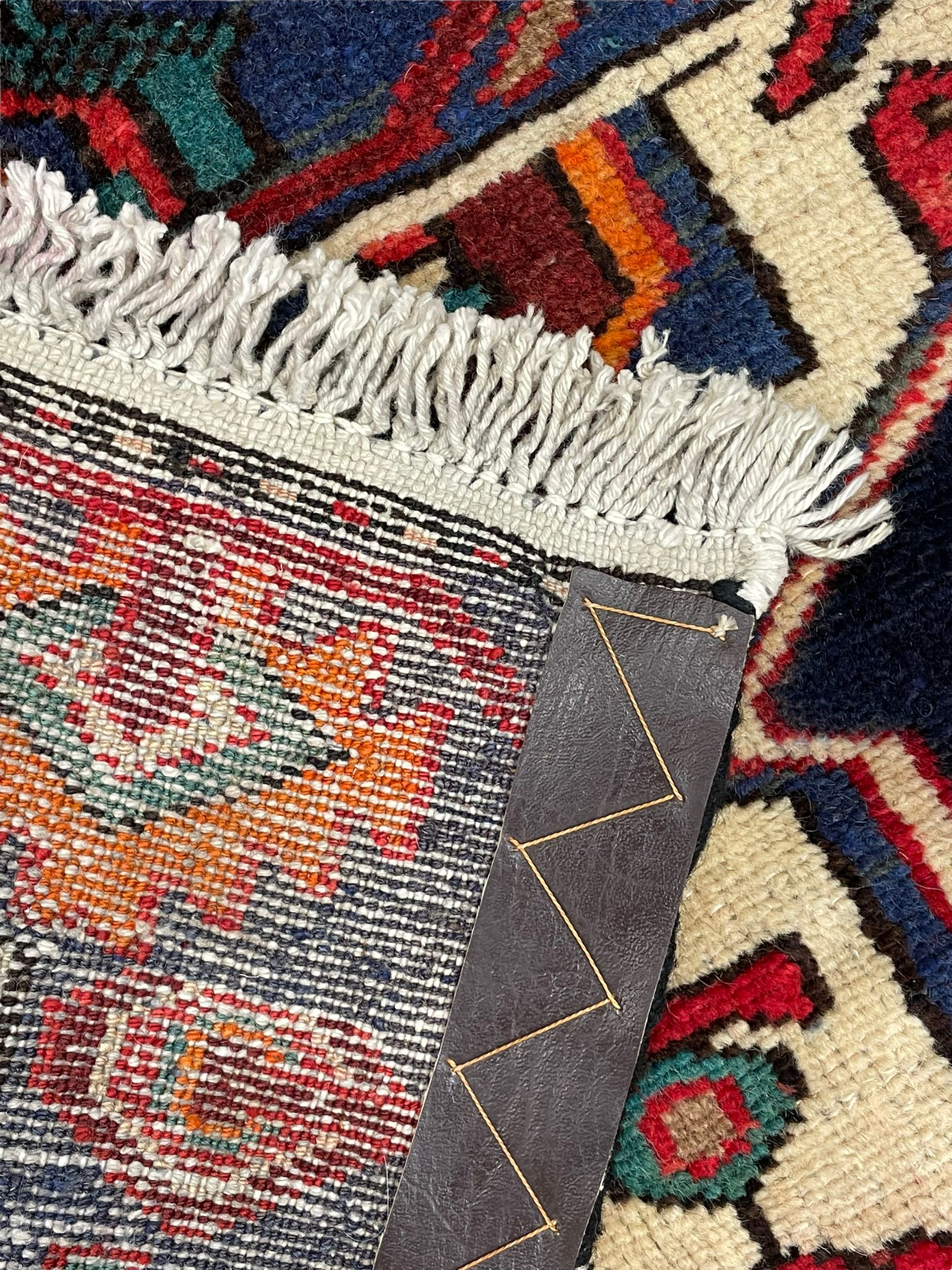 North West Persian Heriz rug, blue and ivory ground, decorated with stylised plant motifs, the border decorated with repeating geometric design 