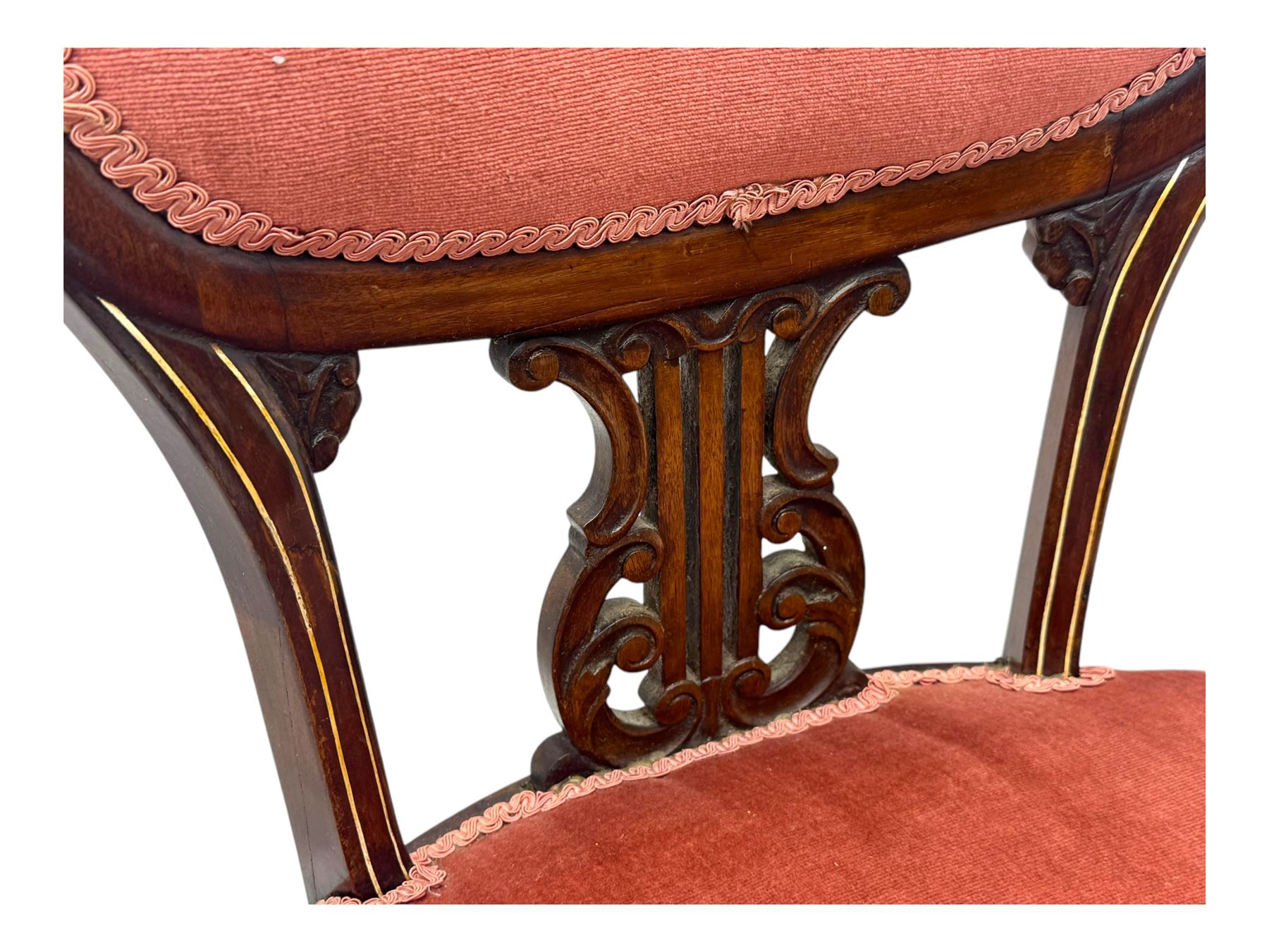 Pair of Edwardian inlaid rosewood salon chairs, upholstered in dusky pink fabric with gimp trim, oval backrest with carved crest rail with central shell motif and pierced splat, on cabriole supports terminating in castors