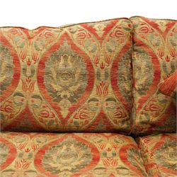 Duresta - traditional shape two-seat sofa with out-swept arms, upholstered in crimson ground fabric decorated with palmettes and foliate motifs with matching loose and scatter cushions, raised on compressed bun feet with brass cups and castors
