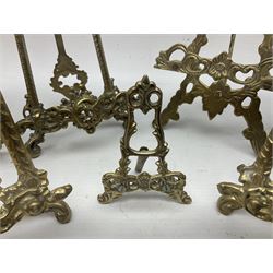 Nine ornate cast brass easel stands of various sizes, H24cm