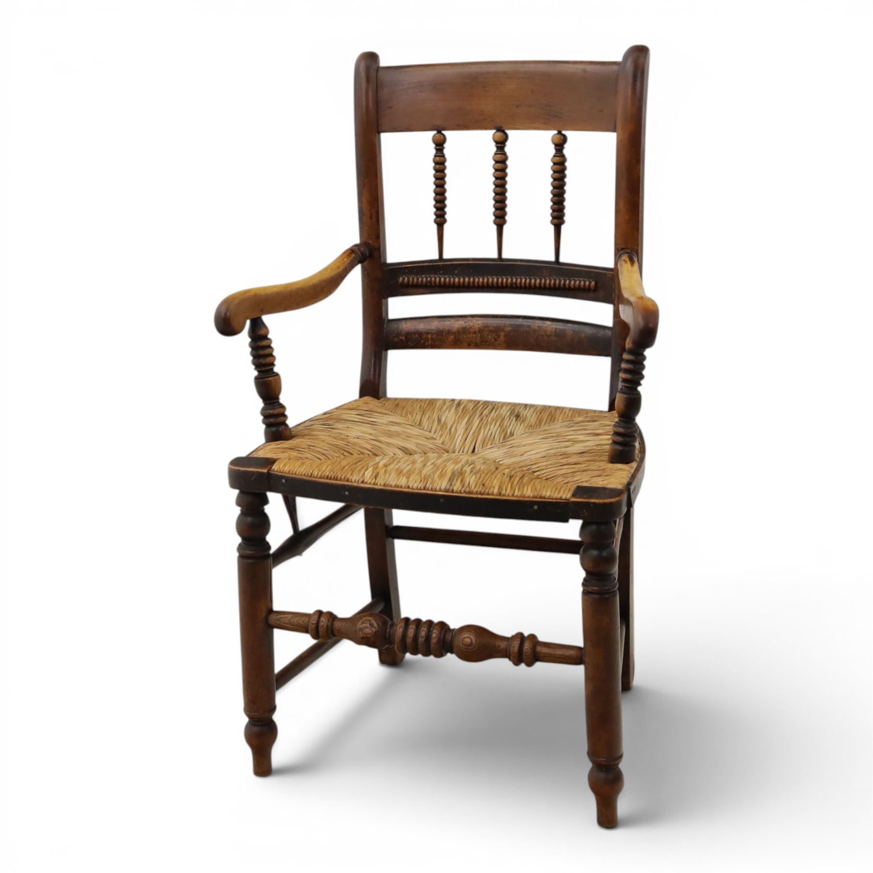 19th century elm chair, with curved top rail and bobbin turned spindles, woven rush seat, on turned legs united by front stretcher