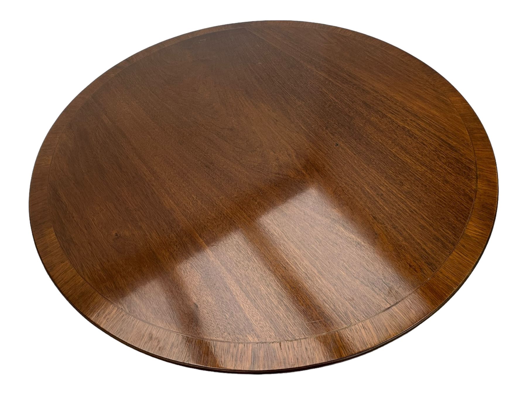 Early 20th century Regency design mahogany tilt-top table, circular top with edge banding, supported by a central turned pedestal with four reeded sabre supports terminating in castors; six chairs with pink upholstered drop in seats (7)