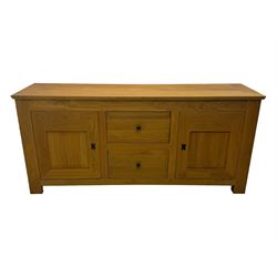Contemporary light oak sideboard, chamfered rectangular top over two central bevel-edged drawers, flanked by two recessed panelled cupboards enclosing shelving, on square stile supports