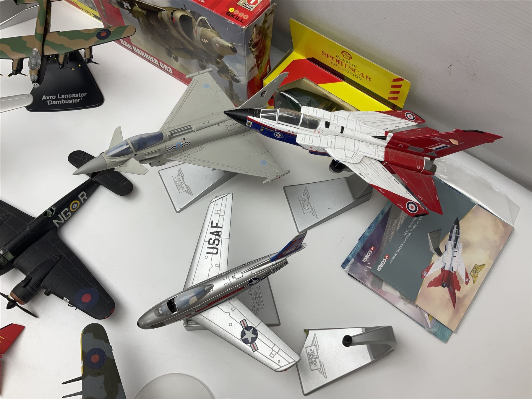 Thirteen unboxed Corgi Aviation Archive or similar die-cast models of aircraft, most with stands; Airfix 1:72 scale construction kit for BAe Harrier GR3; and two boxed Shell Collection die-cast models of cars
