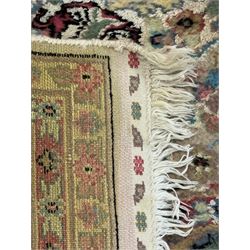 Persian design ivory ground rug, overall floral design with shaped central medallion, the main border decorated with trailing flower head pattern, within guard stipes 